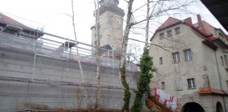 Transformation: Konzert in Straumers Umspannwerk. Saarländer Ro Gebhardt mit Gitarre in Berlin-Frohnau Blick vom S-Bahnhof Frohnau Richtung Ludolfingerplatz, Baustelle mit Richtfest im Vordergrund, Berlin-Frohnau
