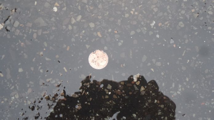 Das Geld liegt auf der Straße. 2-Cent-Münze liegt auf dem Berliner Asphalt vor dem Patentamt.