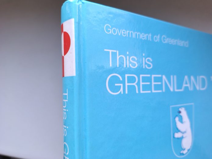 Umschlag des Buches "This is Greenland '99" der Regierung / Government of Greenland als Illustration zum Film Greenland 2 von Ric Roman Waugh, Darsteller/ Schauspieler: John Garrity (Gerard Butler), Allison Garrity (Morena Baccarin), Sohn Nathan Garrity (Roman Griffin Davis). Im Verleih Tobis-Film. Bundesweiter Kinostart 8. Januar '26 (2026).